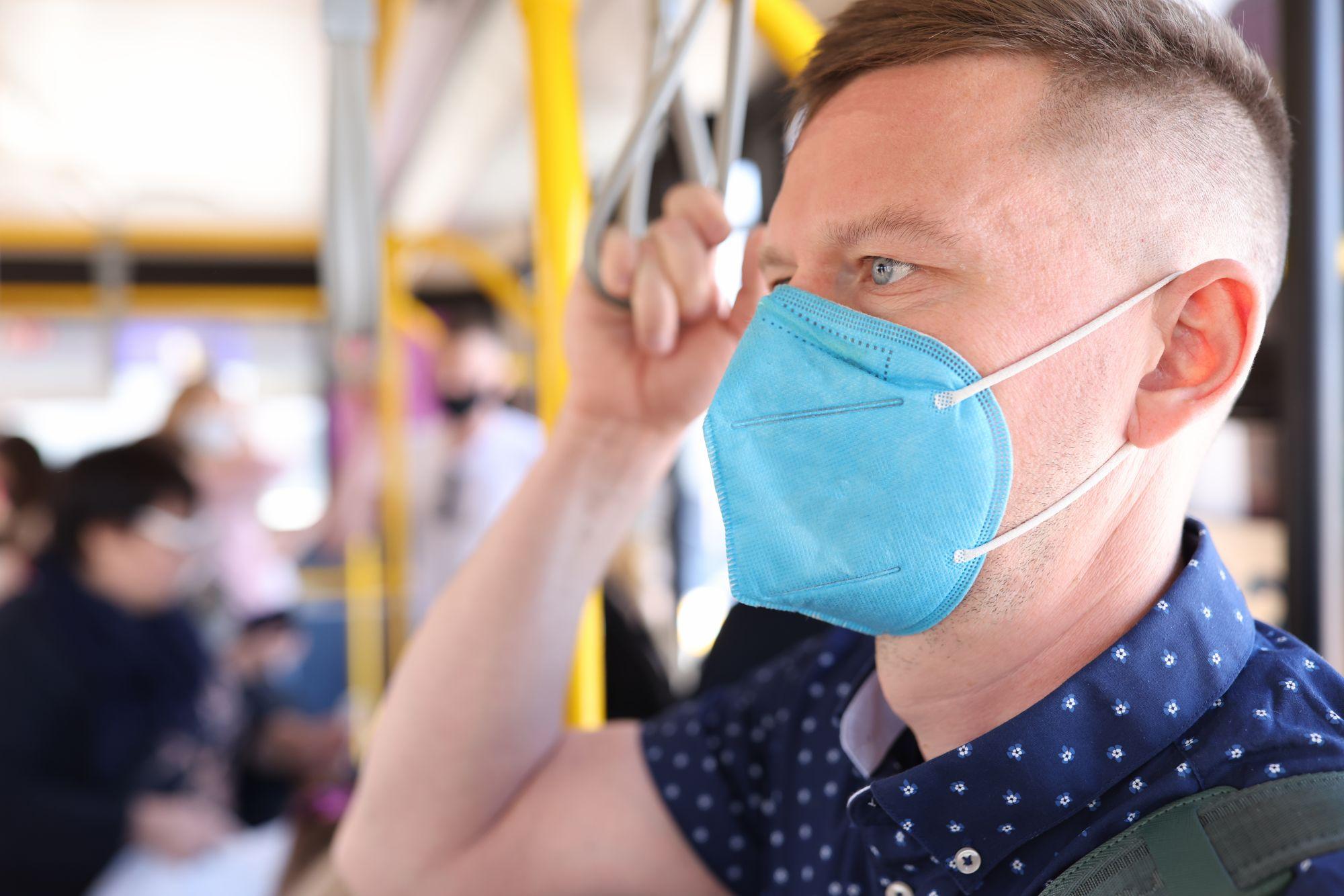 Un bărbat cu mască de protecție într-un autobuz