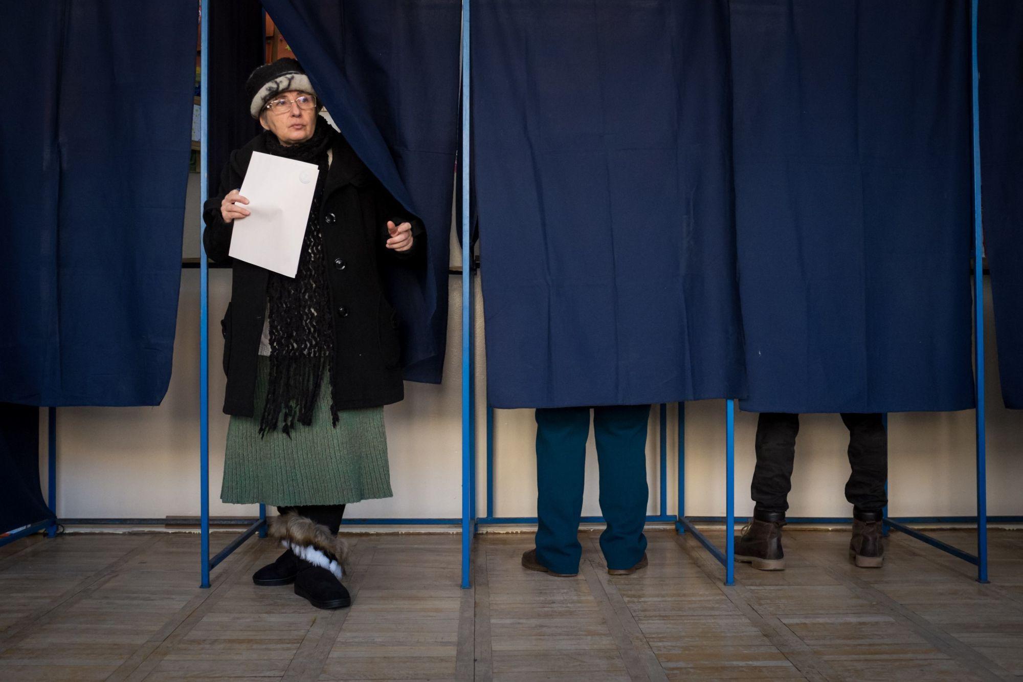 O femeie iese din cabina de vot, după alegerile parlamentare din 2016 O femeie iese din cabina de vot, după alegerile parlamentare din 2016