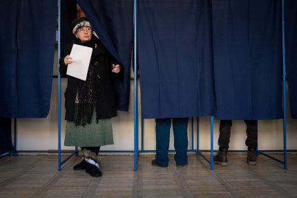 O femeie iese din cabina de vot, după alegerile parlamentare din 2016