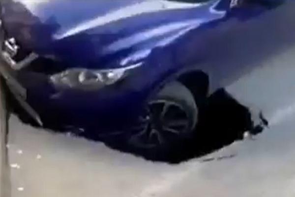 Mașină, la un pas de a fi înghițită de asfalt pe un bulevard din Craiova. Autoturismul a rămas suspendat cu roata din faţă deasupra gropii