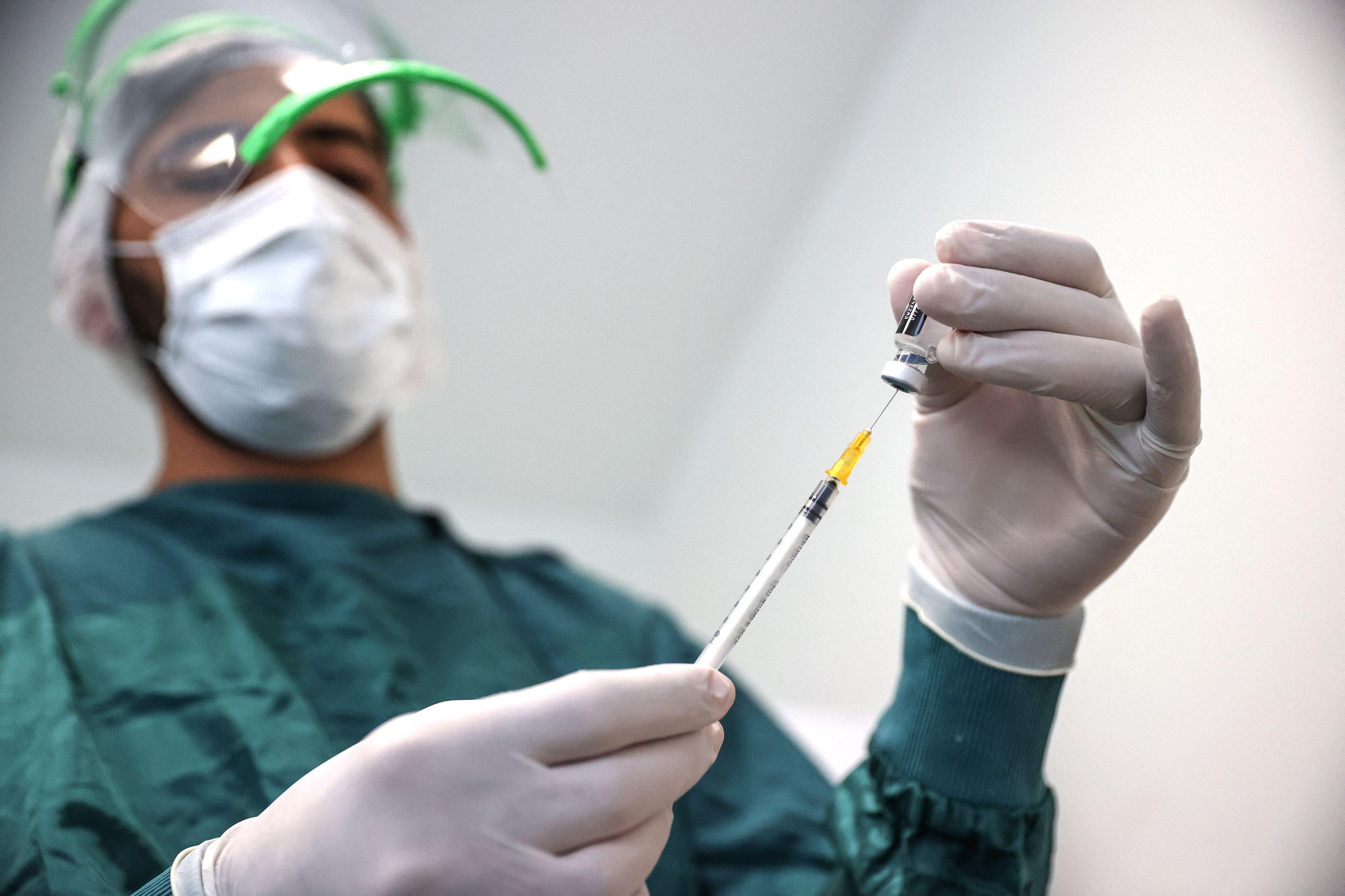Un asistent pregăteste o seringă cu vaccinul anti-Covid
