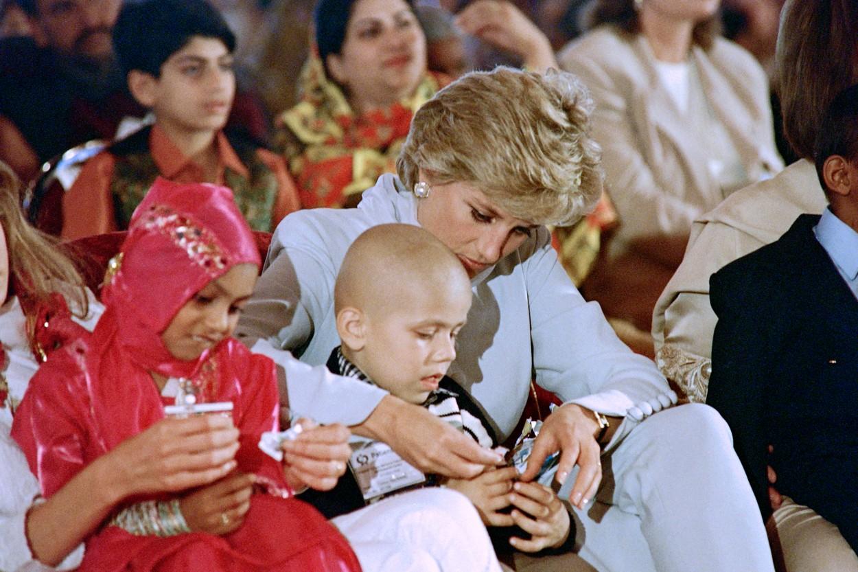 Prințesa Diana hrănește un copil afectat de cancer, în timpul unui spectacol prezentat de copii la spitalul de cancer memorial Khanum, din 22 februarie 1996, din Lahore.