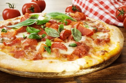 pizza margherita asezată pe un suport de lemn