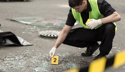 Poliţist care investighează zona unui accident