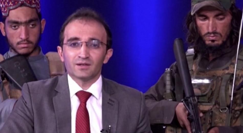Un prezentator TV afgan, înconjurat de opt talibani înarmați, transmite un mesaj populației. Militanții au dat buzna în platou cu puști de asalt