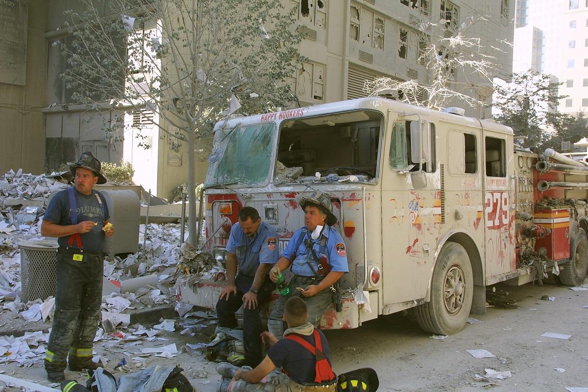 Pompierii din New York se odihnesc lângă World Trade Center, după ce două avioane deturnate s-au prăbușit în Turnurile Gemene, 11 septembrie 2001