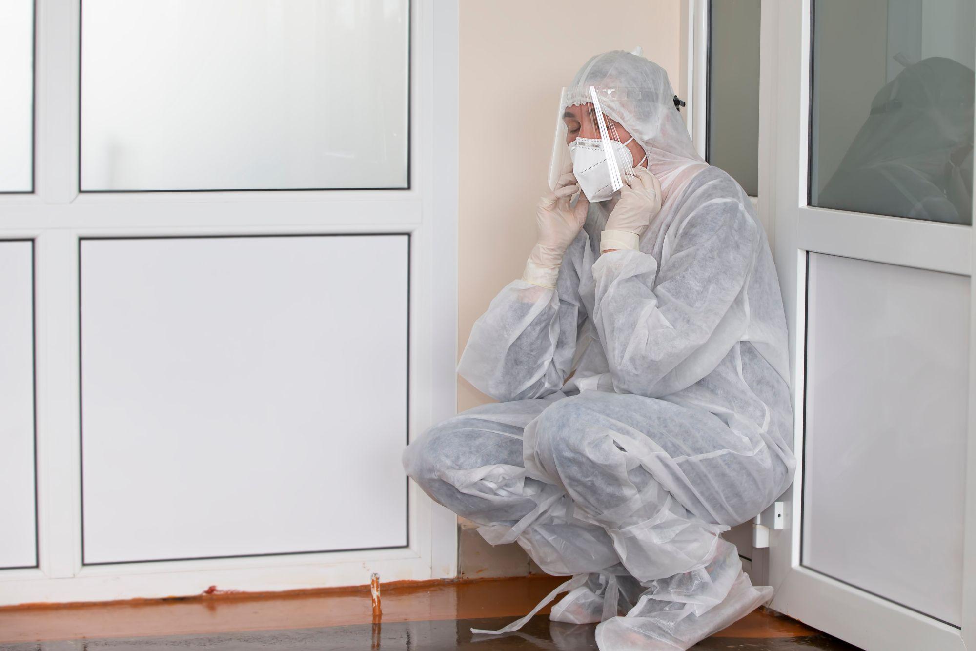 Un medic, extenuat în haine de protecţie, în timpul pandemiei de coronavirus