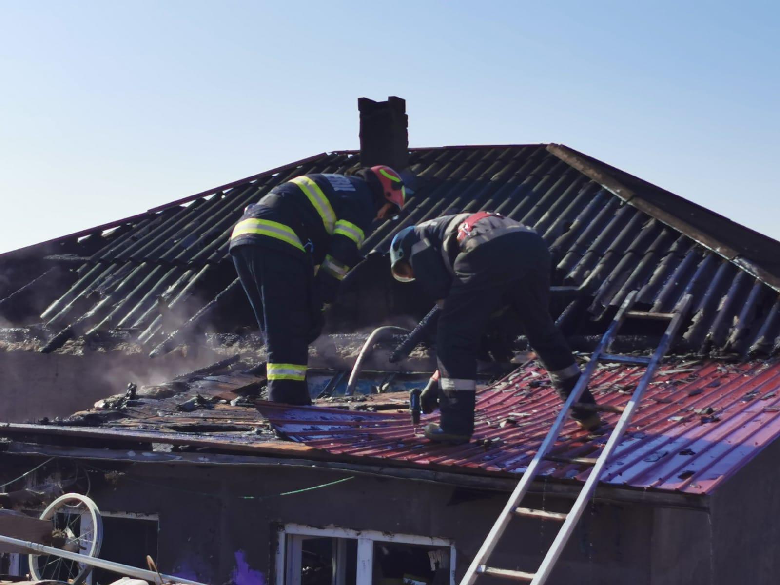 Pompierii ISU Botoșani intervin la stingerea incendiului care le-a cuprins casa celor doi frați din Roșiori