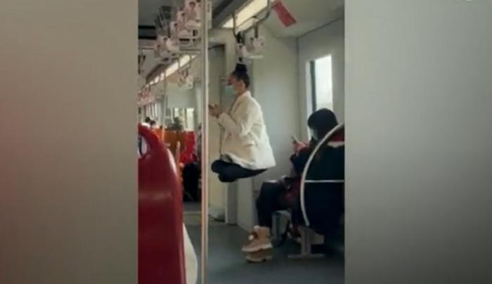 Rusoaică filmată "levitând" la metroul din Shanghai. A stat agăţată cu părul de o bară, lăsându-i mască pe pasageri
