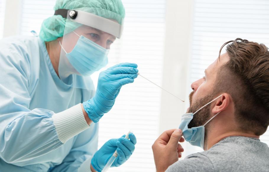Bilanț coronavirus în România, 27 ianuarie. Doctor intr-un costum de protectie luand proba pentru testul covid