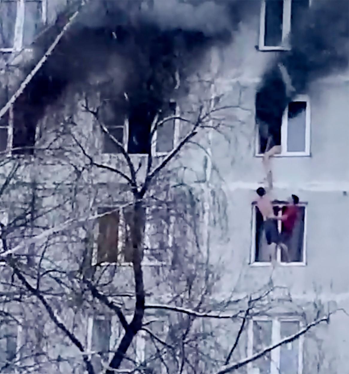 Momentul înfricoșător în care o fată de 18 ani este salvată de iubitul ei și un alt tânăr dintr-un apartament în flăcări, situat la etajul 9, în Moscova