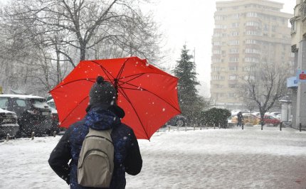 Trecatorii circula in timpul unei nisori in zona Pietei Victoriei din Bucuresti