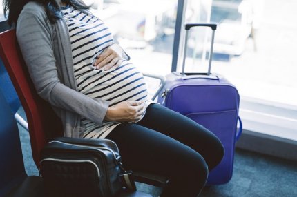 femeie gravidă în aeroport