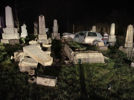 O maşină aflată printre morminte, după ce şoferul a pierdut contrololul volanului şi a ajuns în cimitir