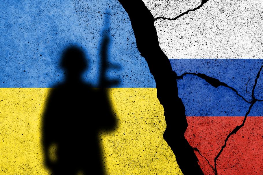Război Rusia - Ucraina. Desfășurarea evenimentelor pe zile Steagurile Ucrainei şi Rusiei, pe un zid, şi umbra unui soldat