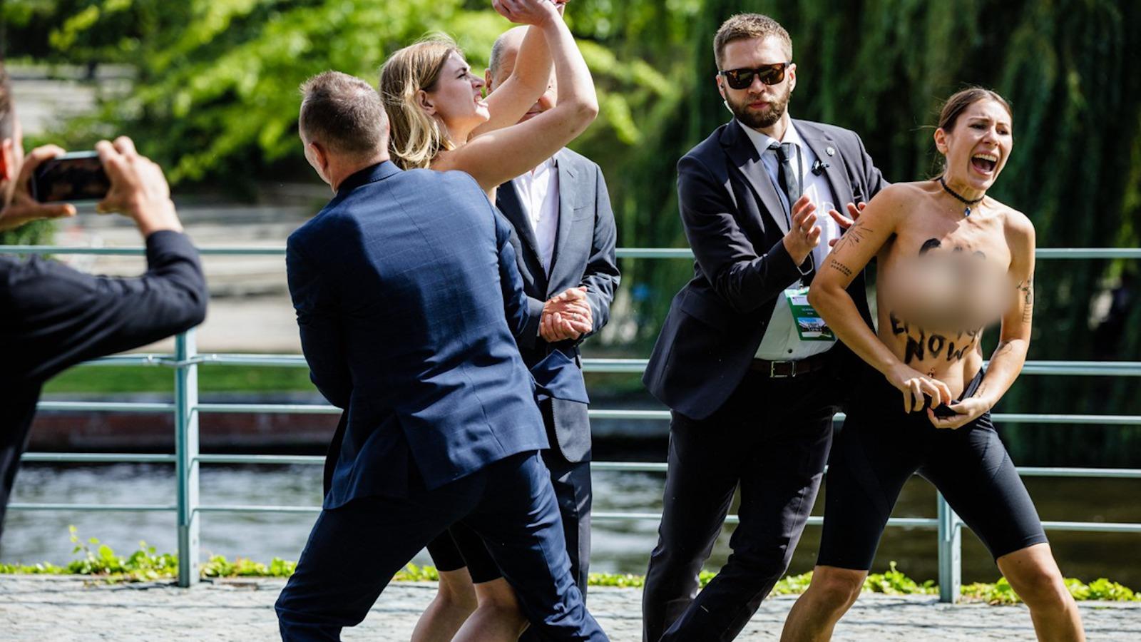 Două activiste au venit în sânii goi lângă Olaf Scholz. Mesajul scris pe piept: "Embargo asupra gazului, acum"