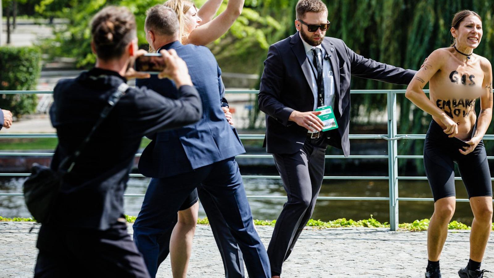 Două activiste au venit în sânii goi lângă Olaf Scholz. Mesajul scris pe piept: "Embargo asupra gazului, acum"