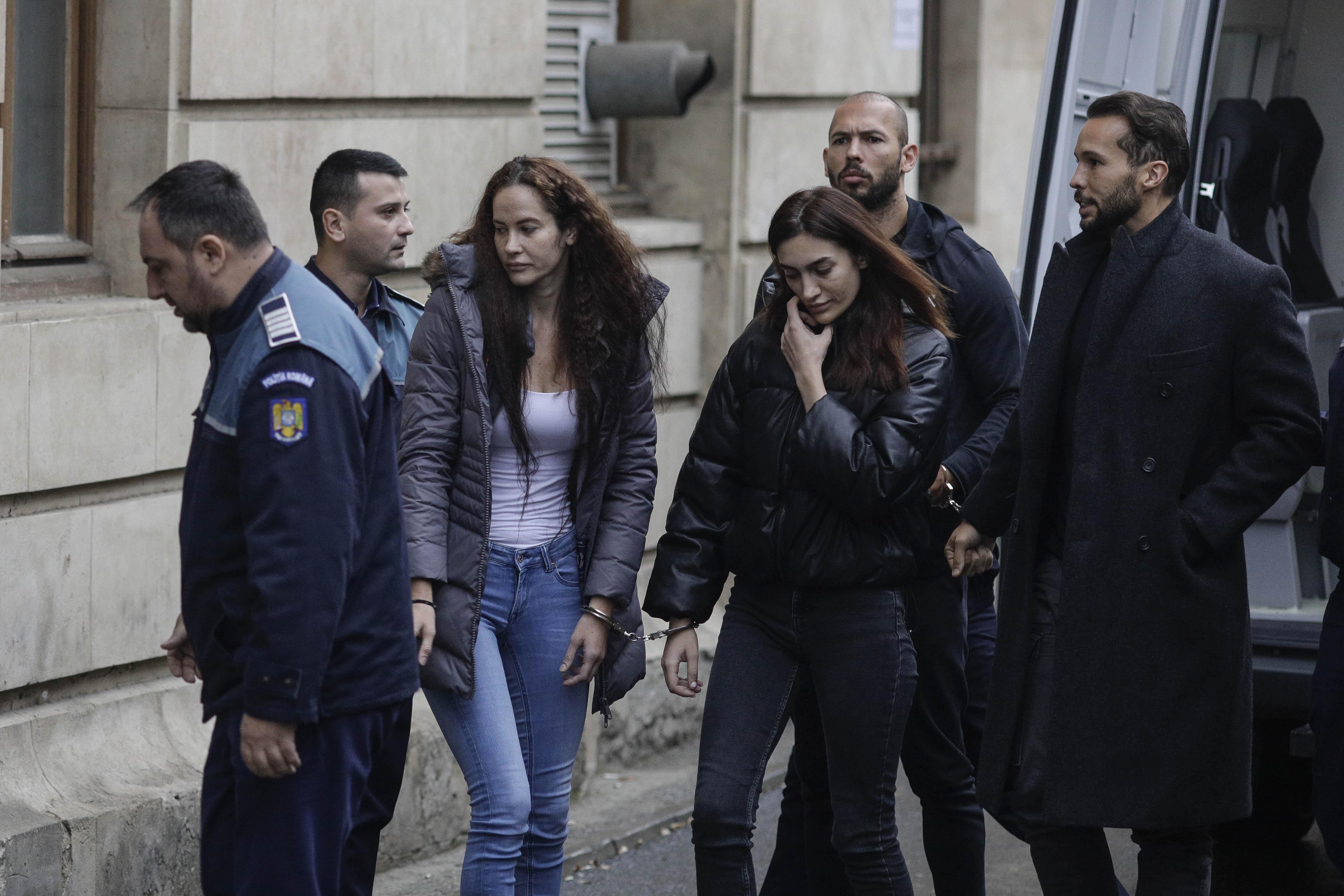 Fraţii Tate aduşi la instanţă cu duba, încătuşaţi. Andrew ţinea în mână un Coran