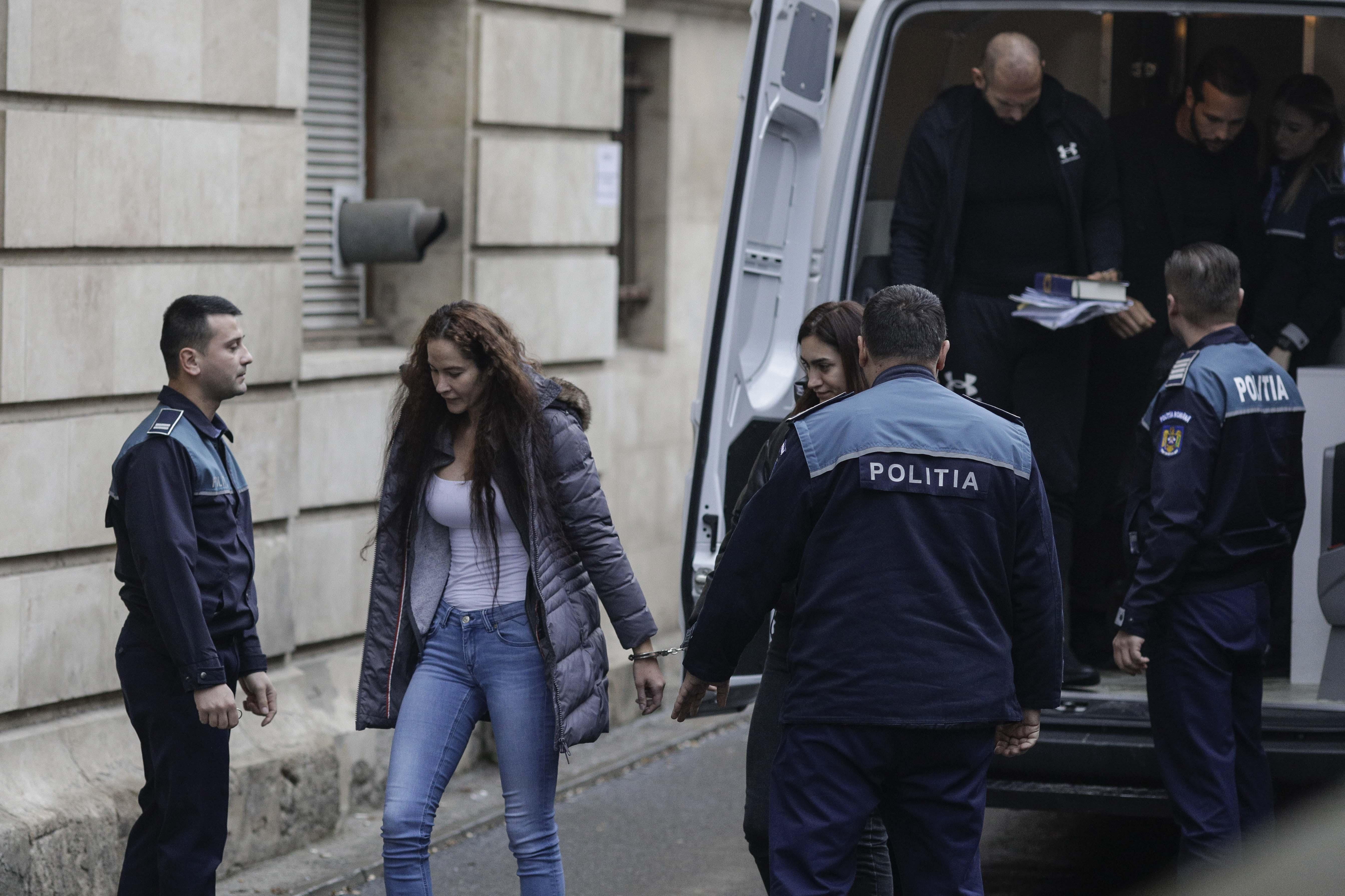 Fraţii Tate aduşi la instanţă cu duba, încătuşaţi. Andrew ţinea în mână un Coran