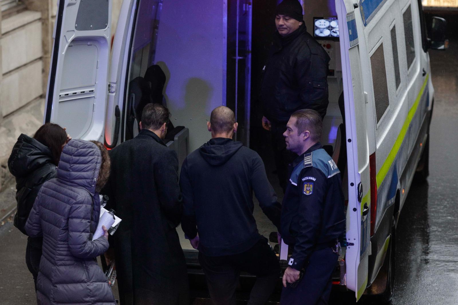 Fraţii Tate, legaţi amândoi cu o pereche de cătuşe, au stat 5 ore la tribunal. Mesajul afişat de un susţinător