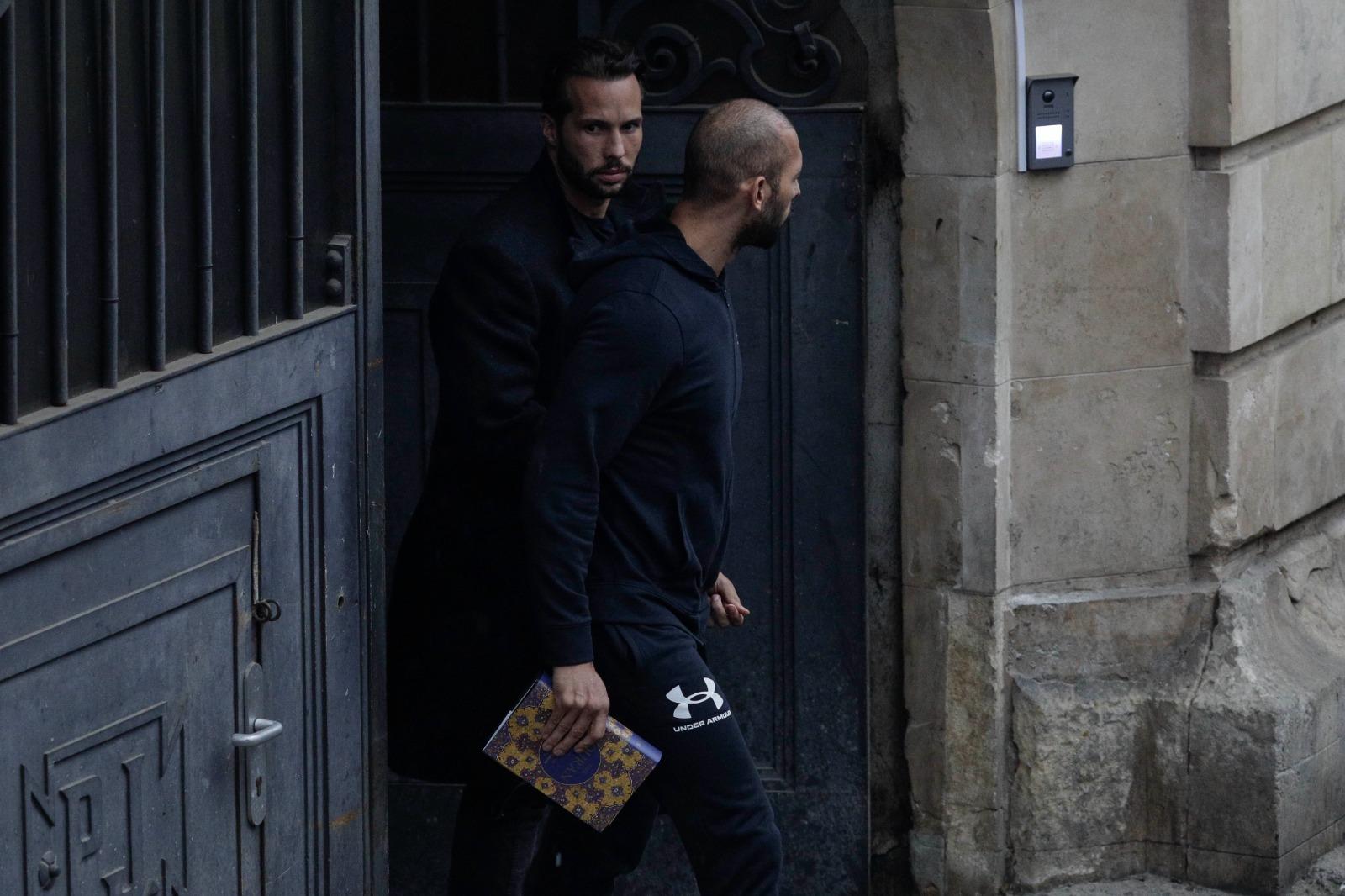 Fraţii Tate, legaţi amândoi cu o pereche de cătuşe, au stat 5 ore la tribunal. Mesajul afişat de un susţinător