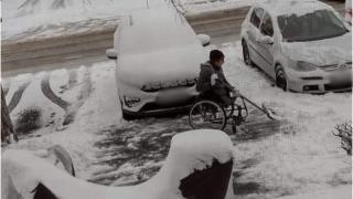 Bărbat în scaun cu rotile, surprins în timp ce face pârtie pe trotuar și curăță zăpada de pe mașinile vecinilor, în Făgăraș: "Ne lasă fără cuvinte"