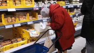 O bătrânică surprinsă în supermarket în timp ce îşi făcea calculele pentru cumpărături. "Foarte trist şi revoltător"