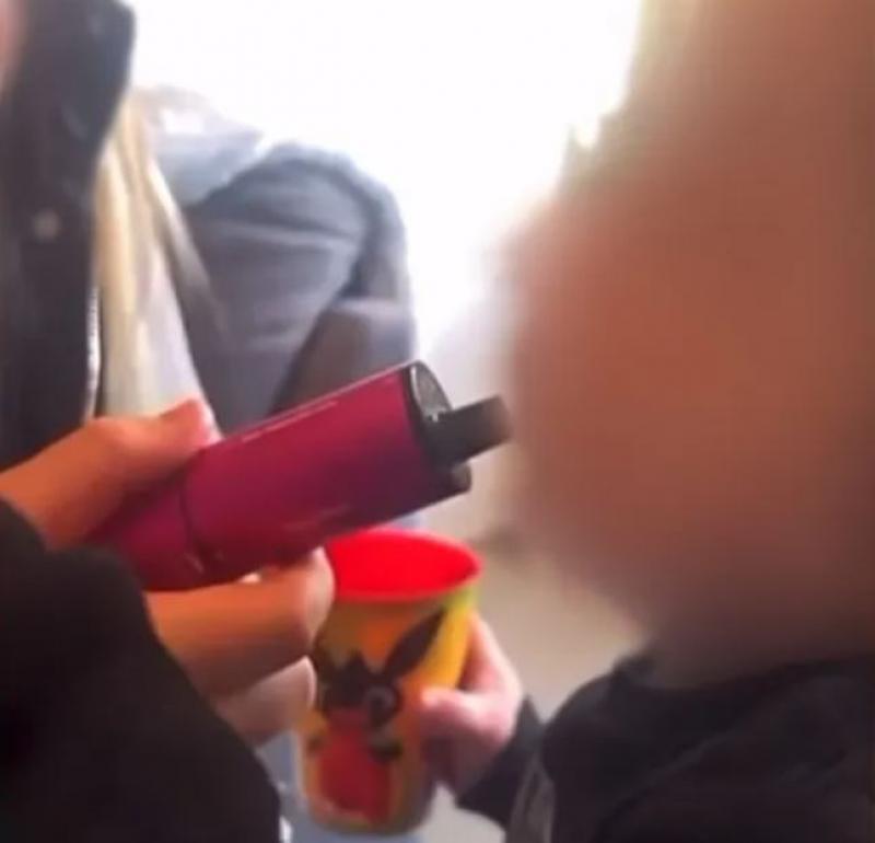 Copilul, filmat cum fumează dintr-o ţigară electronică roz Copilul, filmat cum fumează dintr-o ţigară electronică roz