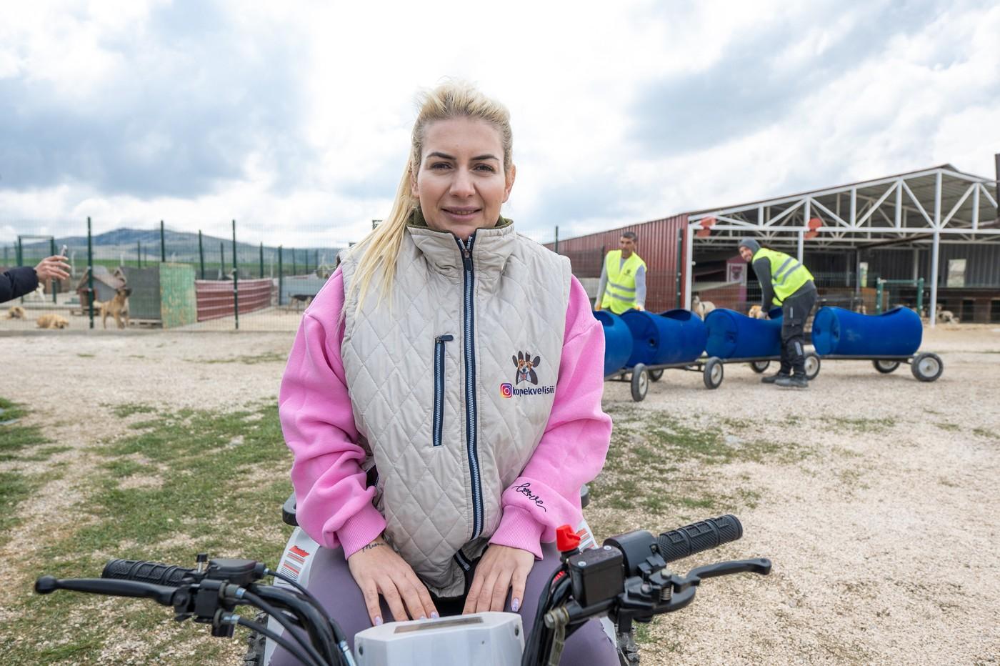 O turcoaică plimbă câinii cu dizabilități cu ajutorul unui trenuleț construit din butoie de plastic