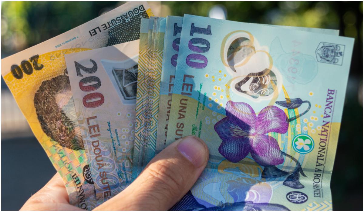 Monedă românească LEI close up. Bancnote românești de 50 100 și 200 de lei în mână