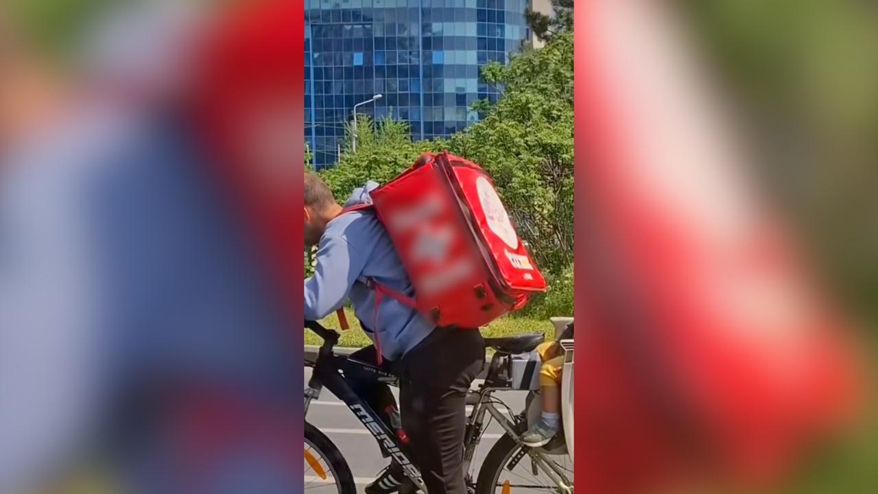 Imagine emoţionantă în Bucureşti: Un livrator surprins cu copilul pe bicicletă, în timp ce îşi ducea comenzile. Micuţul adormise în scaunul său