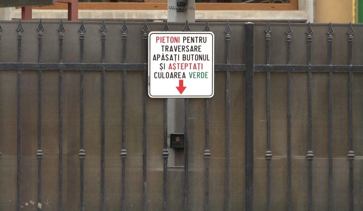 Situaţie ridicolă în Braşov. Pietonii care vor să traverseze apasă butonul semaforului printr-o gaură în gard