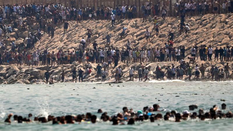 Imagini cutremurătoare la granița Spaniei. Mii de migranți marocani înoată spre țărm și forțează gardurile