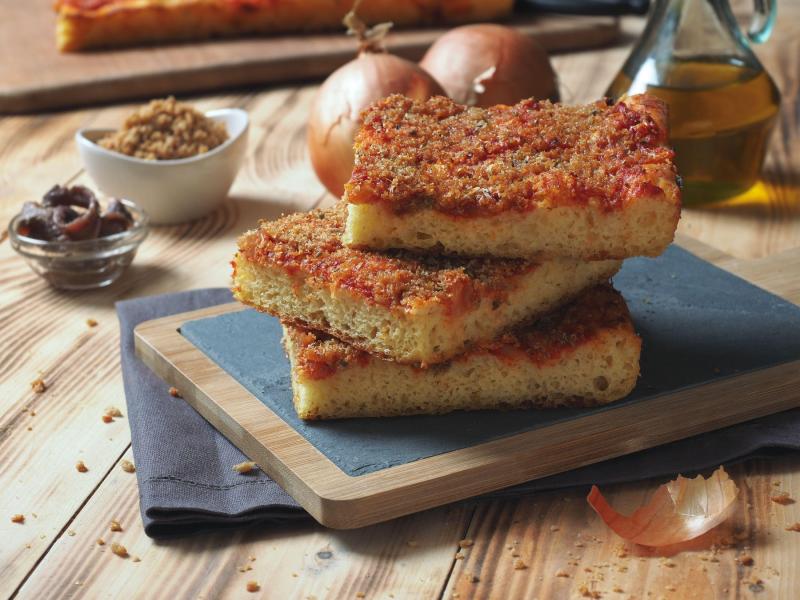 Sfincione este asemănătoare cu o pizza foarte pufoasă, cu blat gros, sos de roșii, ceapă, anșoa și pesmet Sfincione