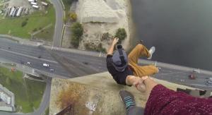 FOTO! Un tânăr atârnă de mâna prietenului său, la peste 100 de metri înălţime