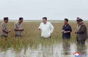Kim Jong Un, furios, în apă până la genunchi, într-un câmp de orez inundat, critică guvernul iresponsabil. Oficialii iau notiţe lângă el, tot în apă