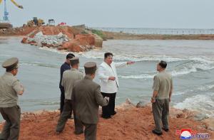 Kim Jong Un, furios, în apă până la genunchi, într-un câmp de orez inundat, critică guvernul iresponsabil. Oficialii iau notiţe lângă el, tot în apă