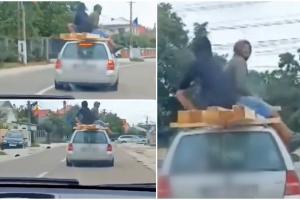 Inconştienţă fără limite: Doi bărbaţi, filmaţi pe plafonul unei maşini aflate în mers, în Suceava. Se sprijineau de nişte lemne