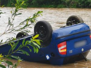 Două persoane au rămas captive într-o maşină răsturnată în râul Bistriţa