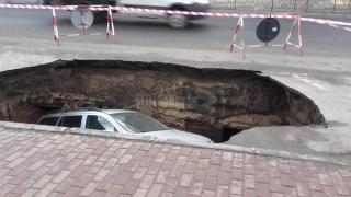 Maşină "ÎNGHIŢITĂ" de un crater într-o parcare din Râmnicu Sărat (VIDEO)
