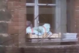 IMAGINI SCANDALOASE! O femeie și-a pus bebeluşul într-o ladă, pe pervazul ferestrei (VIDEO ŞOCANT)