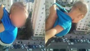 "1000 de LIKE-uri sau îi dau drumul!". Un tată îşi ţine copilul ATÂRNAT de tricou, în afara ferestrei, de la etajul al 15-lea (IMAGINI ŞOCANTE)
