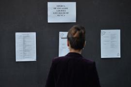 Femeie privește afiș cu oferte de angajare