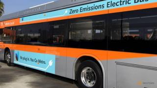 Autobuz hibrid se deplasează pe o stradă