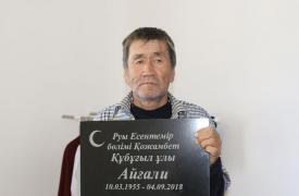 Bărbatul considerat mort ține în mână inscripția de pe mormânt