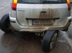 Un şofer din Maramureş şi-a rupt efectiv maşina în două într-un crater plin cu apă de pe şosea (Foto)