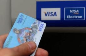 Card Visa în faţa unui bancomat