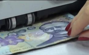 Bancnotă de 100 de lei, într-o maşină de numărat bani