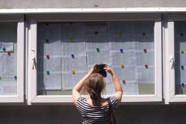 Părinte face poză la afişe cu notele la Bac