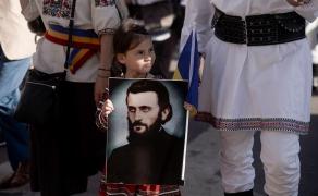 Icoană cu părintele Arsenie Boca, ţinută de un copil